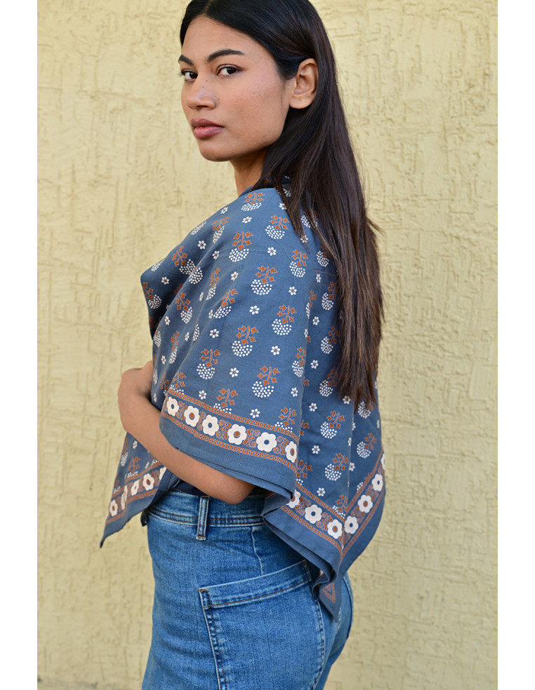 Femme portant le grand foulard Anastase bleu marine 100x100 cm sur les épaules.