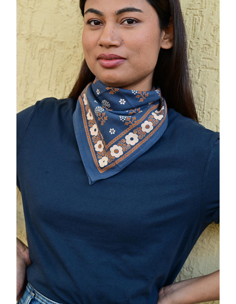 Gros plan sur les motifs floraux fins sur le petit carré bleu marine.