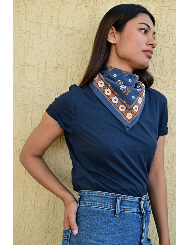 Femme portant le petit foulard Anastase bleu marine 50x50 cm noué autour du cou.