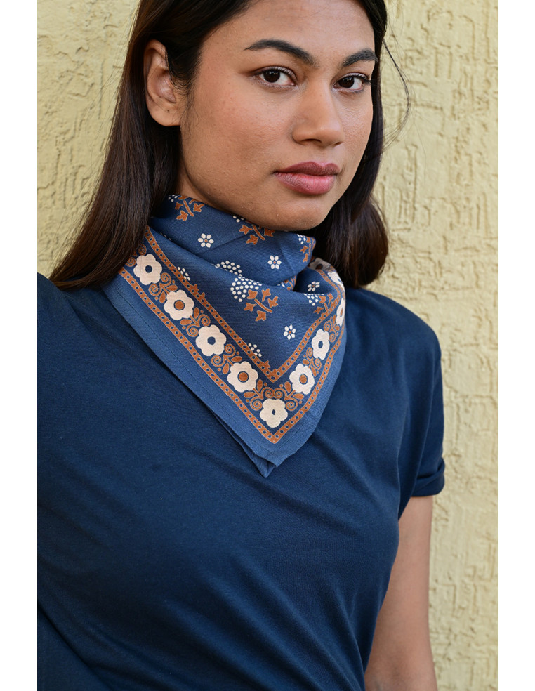 Femme portant le petit foulard Anastase bleu marine 50x50 cm noué autour du cou.