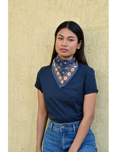 Femme portant le petit foulard Anastase bleu marine 50x50 cm noué autour du cou.