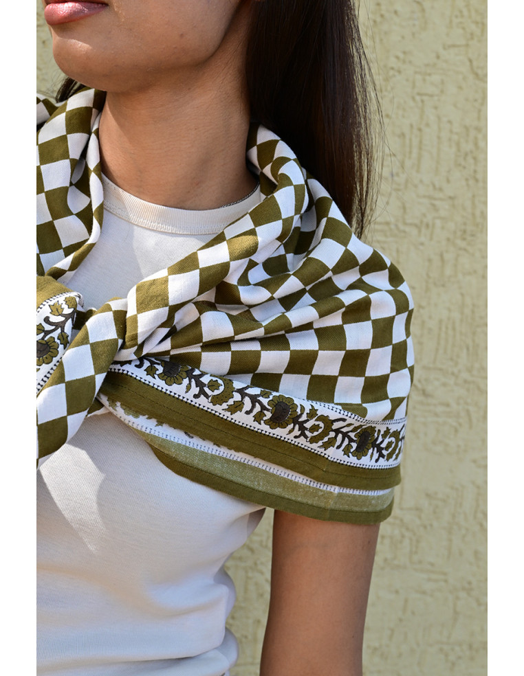 Gros plan sur la bordure florale imprimée au tampon de bois sur fond damier.