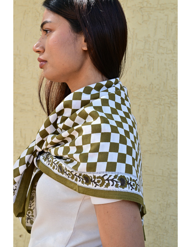 Gros plan sur la bordure florale imprimée au tampon de bois sur fond damier.