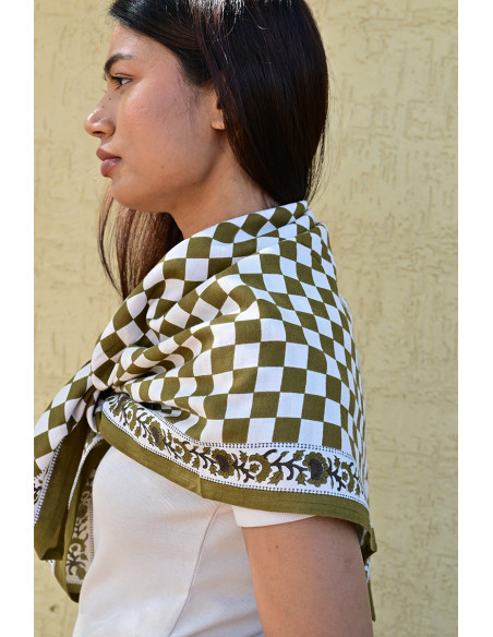 Gros plan sur la bordure florale imprimée au tampon de bois sur fond damier.