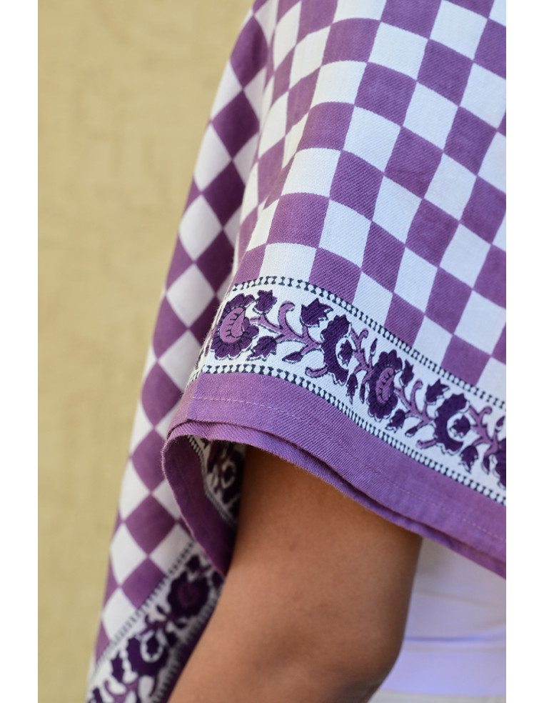 Gros plan sur la bordure florale imprimée au tampon de bois sur fond damier.