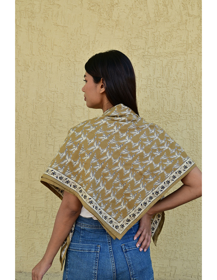 Gros plan sur l'impression blockprint aux encres végétales sur fond brun-olive.