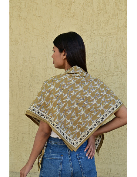 Gros plan sur l'impression blockprint aux encres végétales sur fond brun-olive.