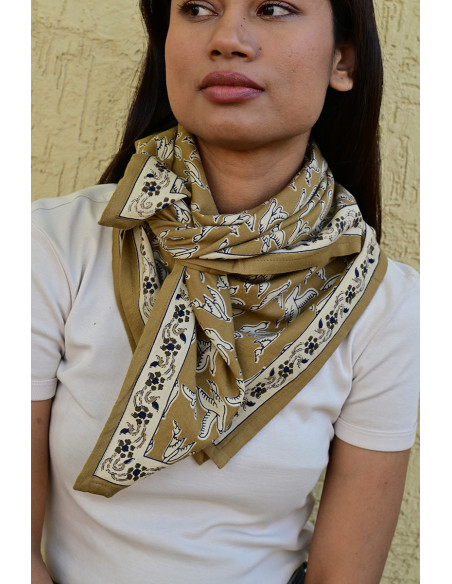 Femme portant le grand foulard Mercure Bistre 100x100 cm noué autour du cou.