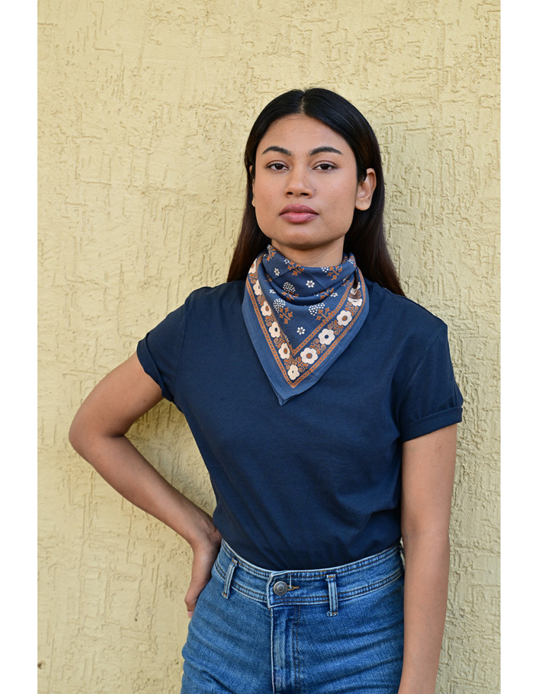Femme portant le petit foulard Anastase bleu marine 50x50 cm noué autour du cou.