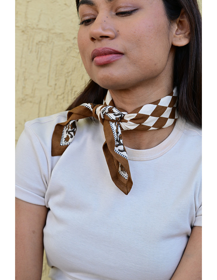 Femme portant le petit foulard Checks Bistre 50x50 cm noué autour du cou.
