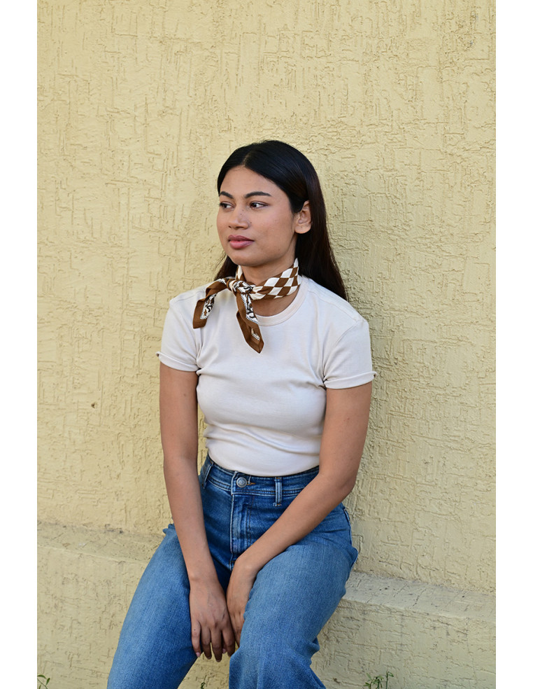 Femme portant le petit foulard Checks Bistre 50x50 cm noué autour du cou.