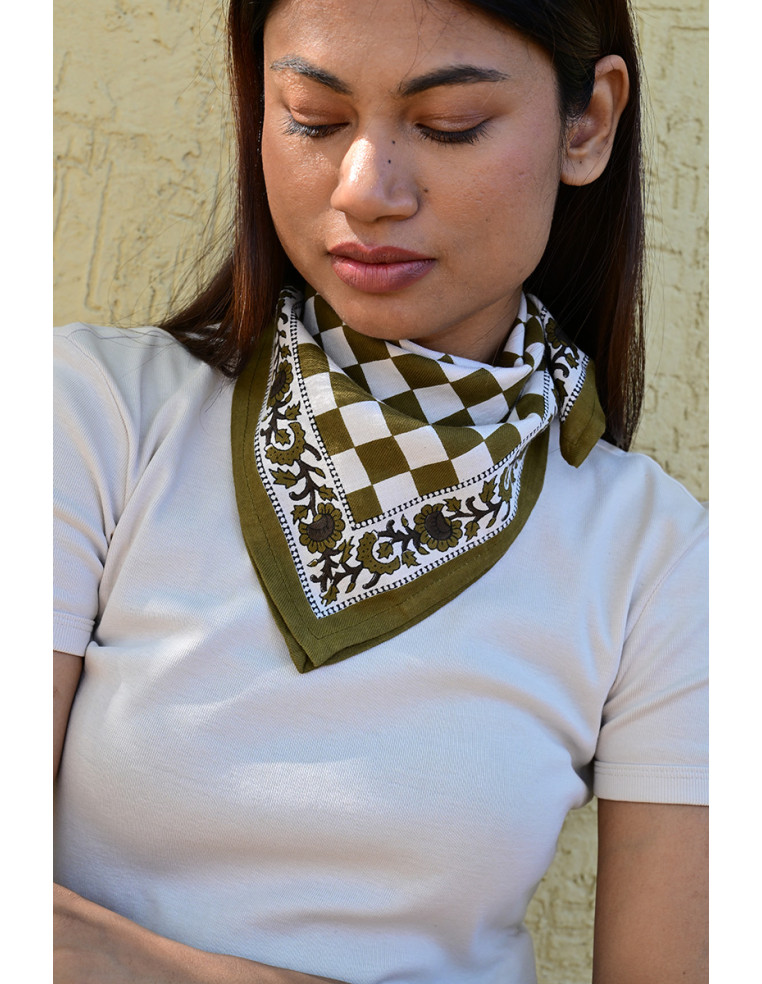 Gros plan sur la bordure florale imprimée au tampon de bois sur fond damier.