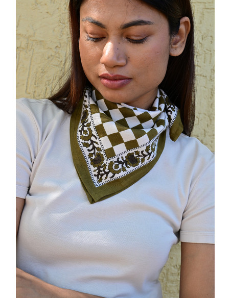 Gros plan sur la bordure florale imprimée au tampon de bois sur fond damier.