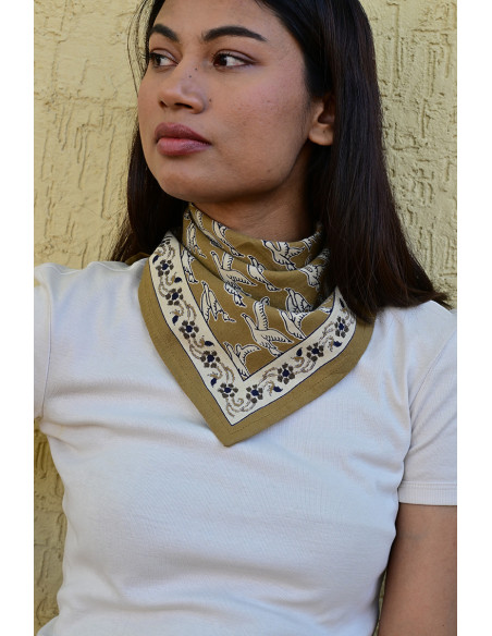 Gros plan sur l'impression blockprint aux encres végétales sur fond brun olive.