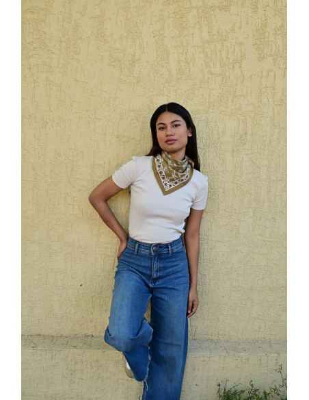 Femme portant le petit foulard Mercure Bistre 50x50 cm noué autour du cou.