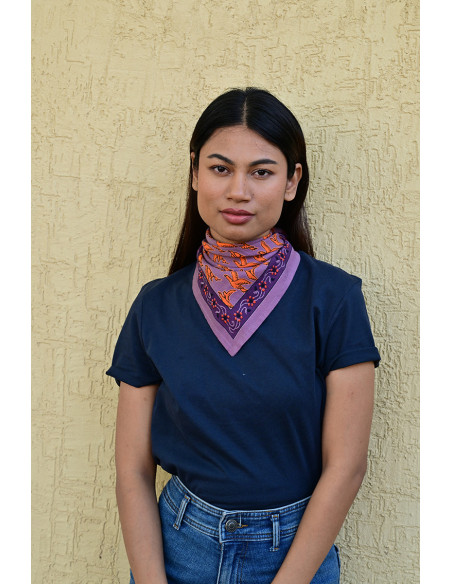 Femme portant le petit foulard Mercure Flame 50x50 cm noué autour du cou.