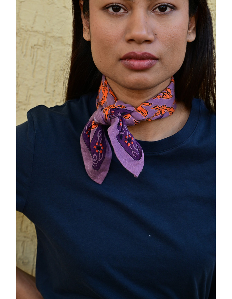 Femme portant le petit foulard Mercure Flame 50x50 cm noué autour du cou.