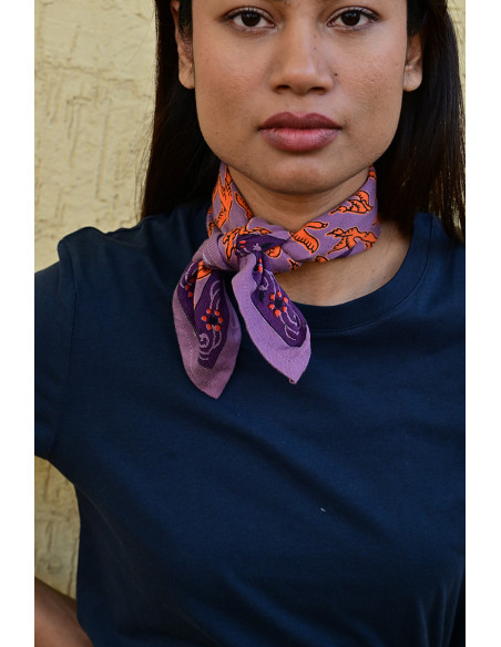 Femme portant le petit foulard Mercure Flame 50x50 cm noué autour du cou.