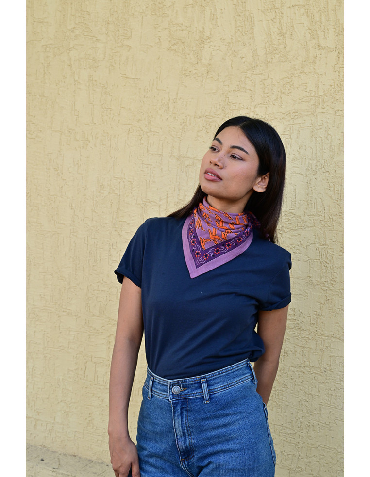 Femme portant le petit foulard Mercure Flame 50x50 cm noué autour du cou.