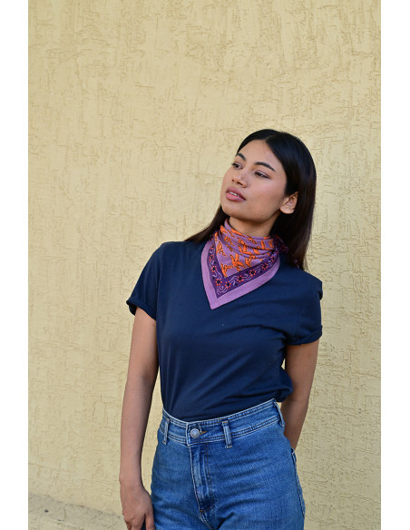 Femme portant le petit foulard Mercure Flame 50x50 cm noué autour du cou.