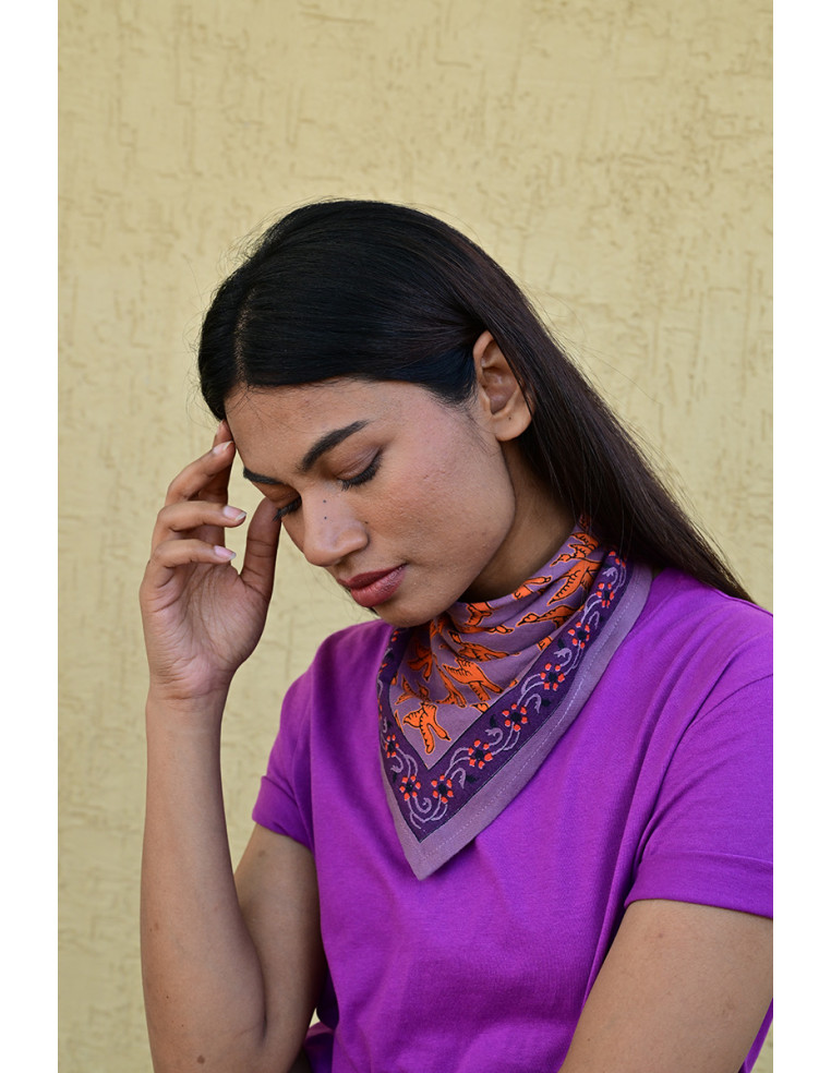 Femme portant le petit foulard Mercure Flame 50x50 cm noué autour du cou.