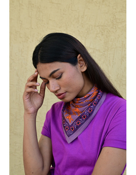 Femme portant le petit foulard Mercure Flame 50x50 cm noué autour du cou.