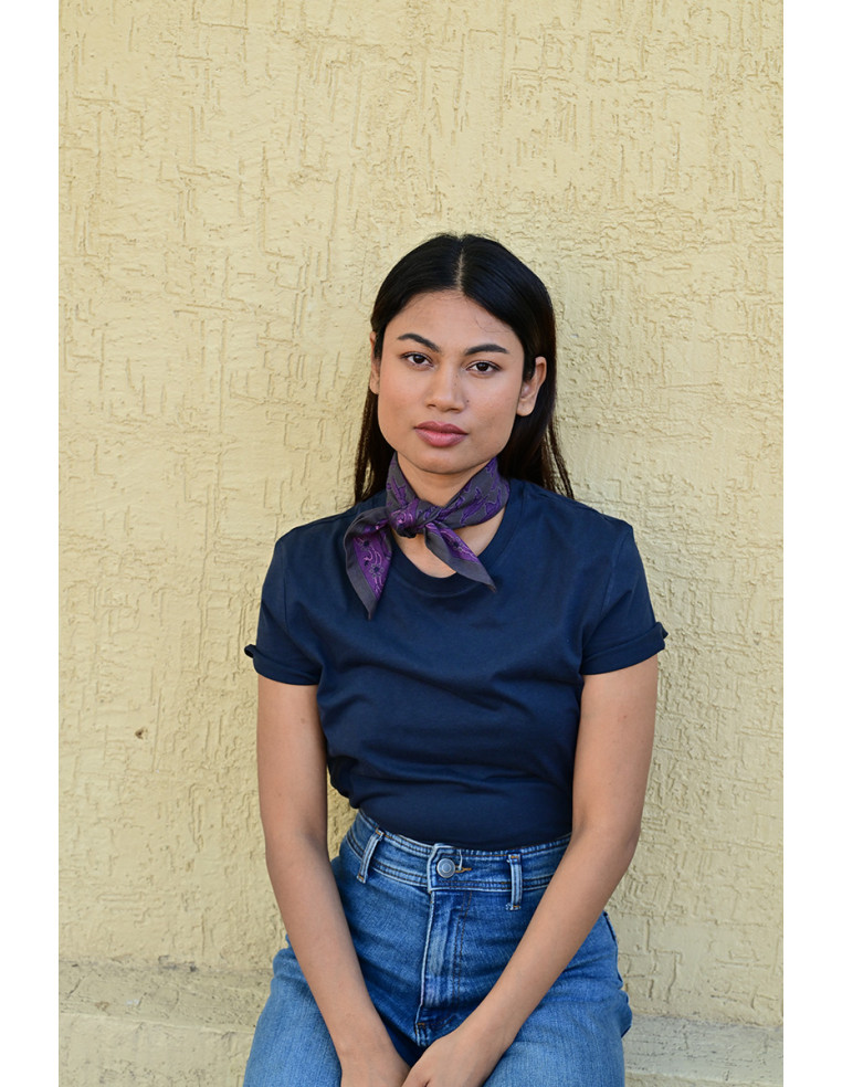 Femme portant le petit foulard Mercure Grisaille 50x50 cm noué autour du cou.