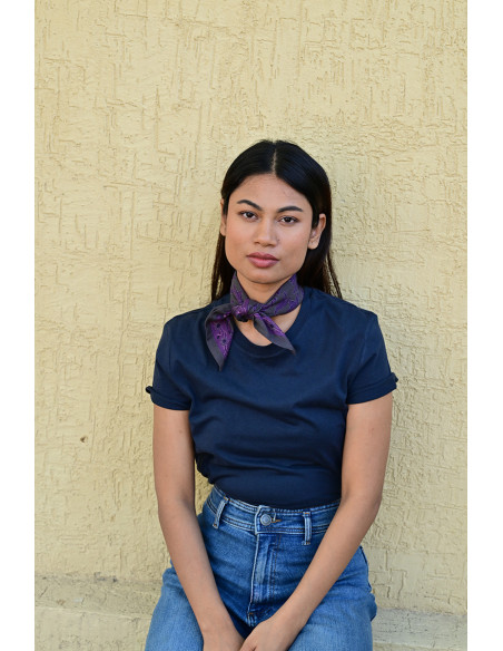 Femme portant le petit foulard Mercure Grisaille 50x50 cm noué autour du cou.