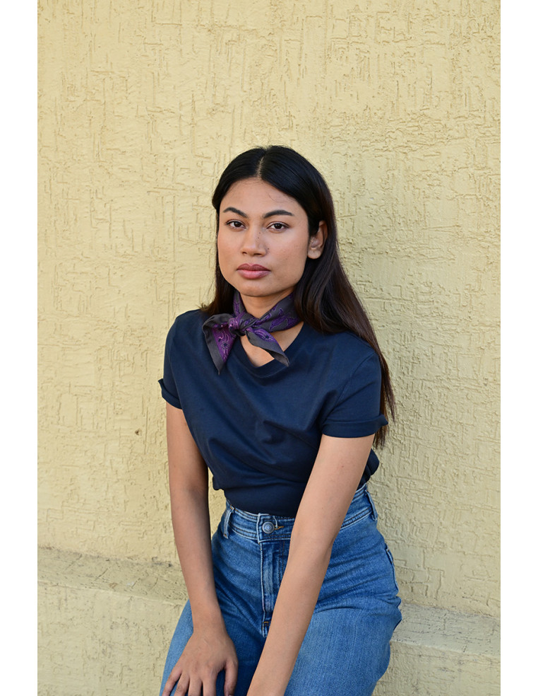 Femme portant le petit foulard Mercure Grisaille 50x50 cm noué autour du cou.