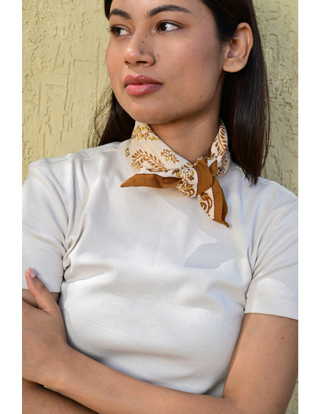 Femme portant le petit foulard Antoinette 50x50 cm noué autour du cou.