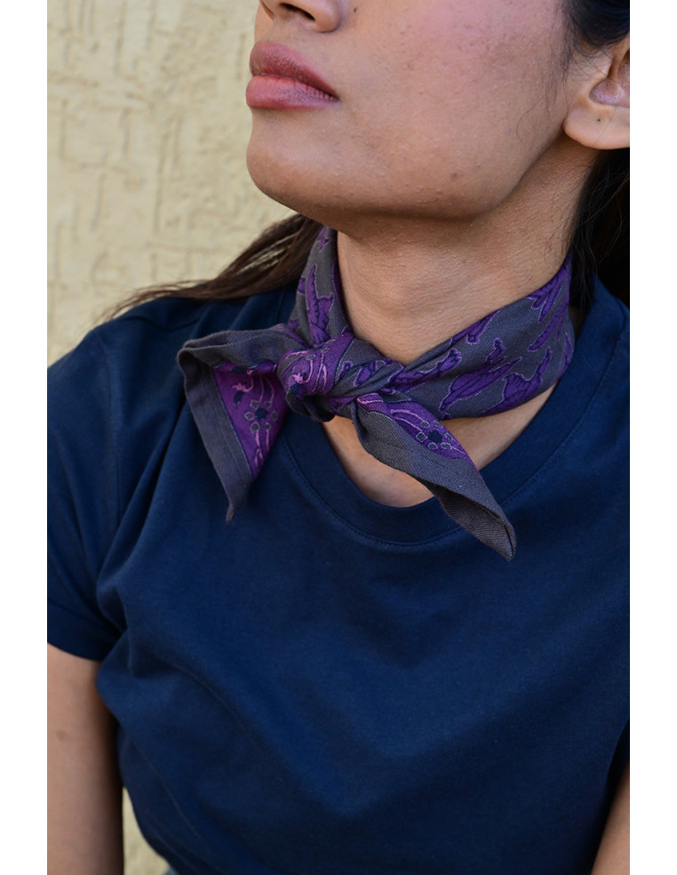 Femme portant le petit foulard Mercure Grisaille 50x50 cm noué autour du cou.