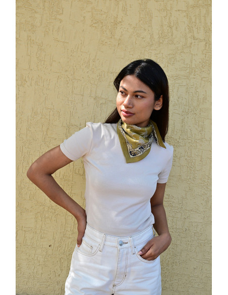 Femme portant le petit foulard Fauve Noix 50x50 cm noué autour du cou.