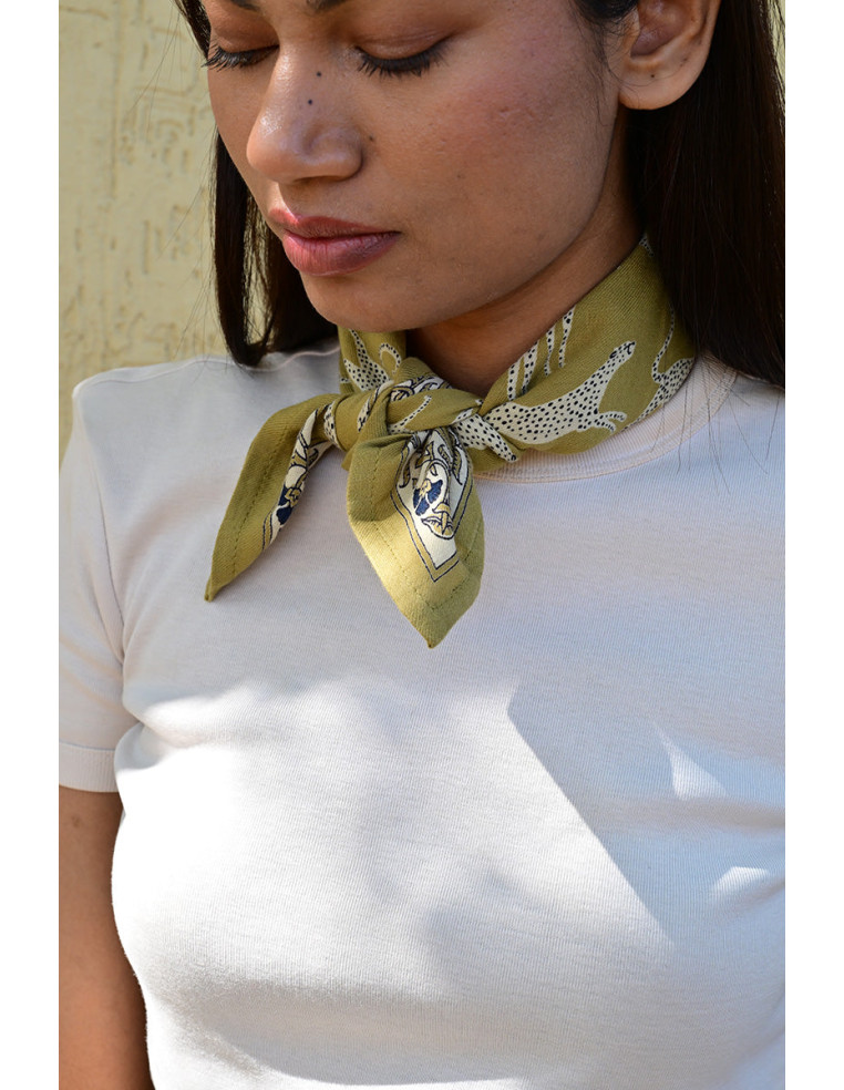 Femme portant le petit foulard Fauve Noix 50x50 cm noué autour du cou.