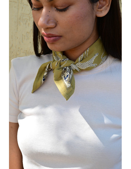 Femme portant le petit foulard Fauve Noix 50x50 cm noué autour du cou.