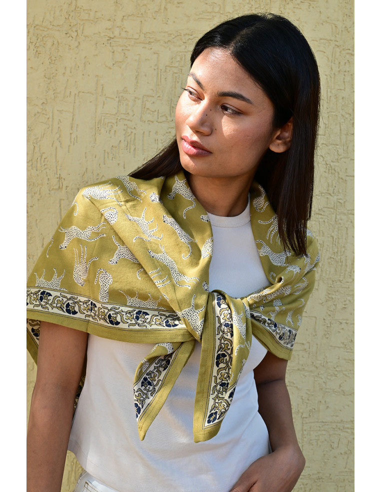 Femme portant le grand foulard Fauve Noix 100x100 cm sur les épaules.