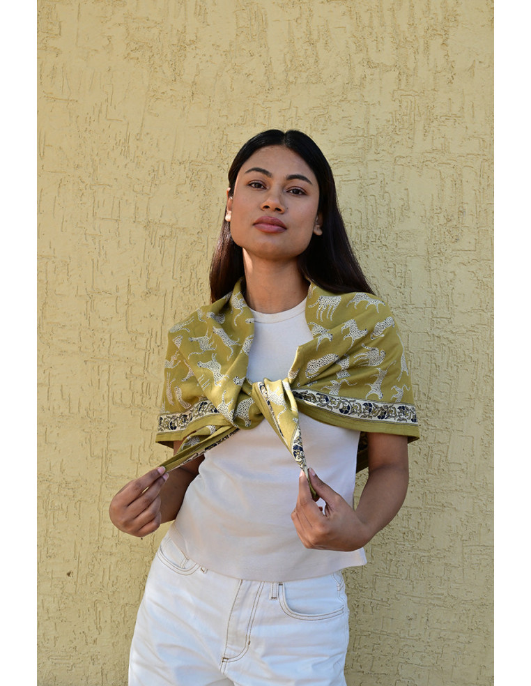 Femme portant le grand foulard Fauve Noix 100x100 cm sur les épaules.