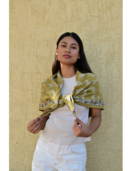 Femme portant le grand foulard Fauve Noix 100x100 cm sur les épaules.