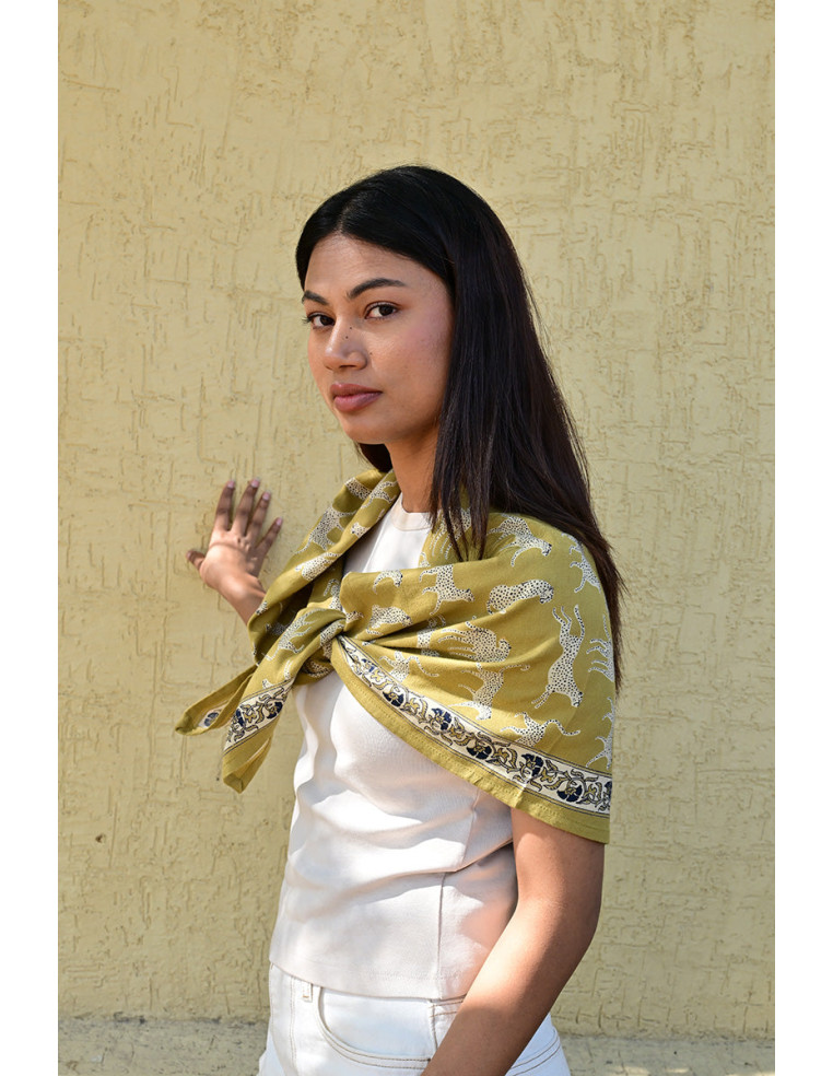 Femme portant le grand foulard Fauve Noix 100x100 cm sur les épaules.