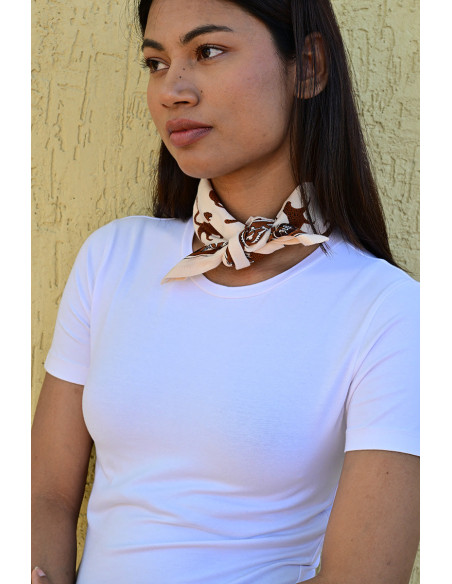 Femme portant le petit foulard Fauve Latte 50x50 cm noué autour du cou.