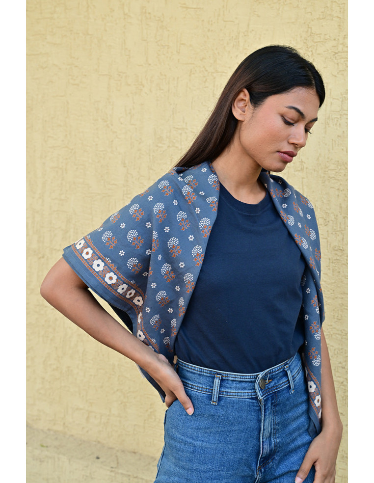 Femme portant le grand foulard Anastase bleu marine 100x100 cm sur les épaules.