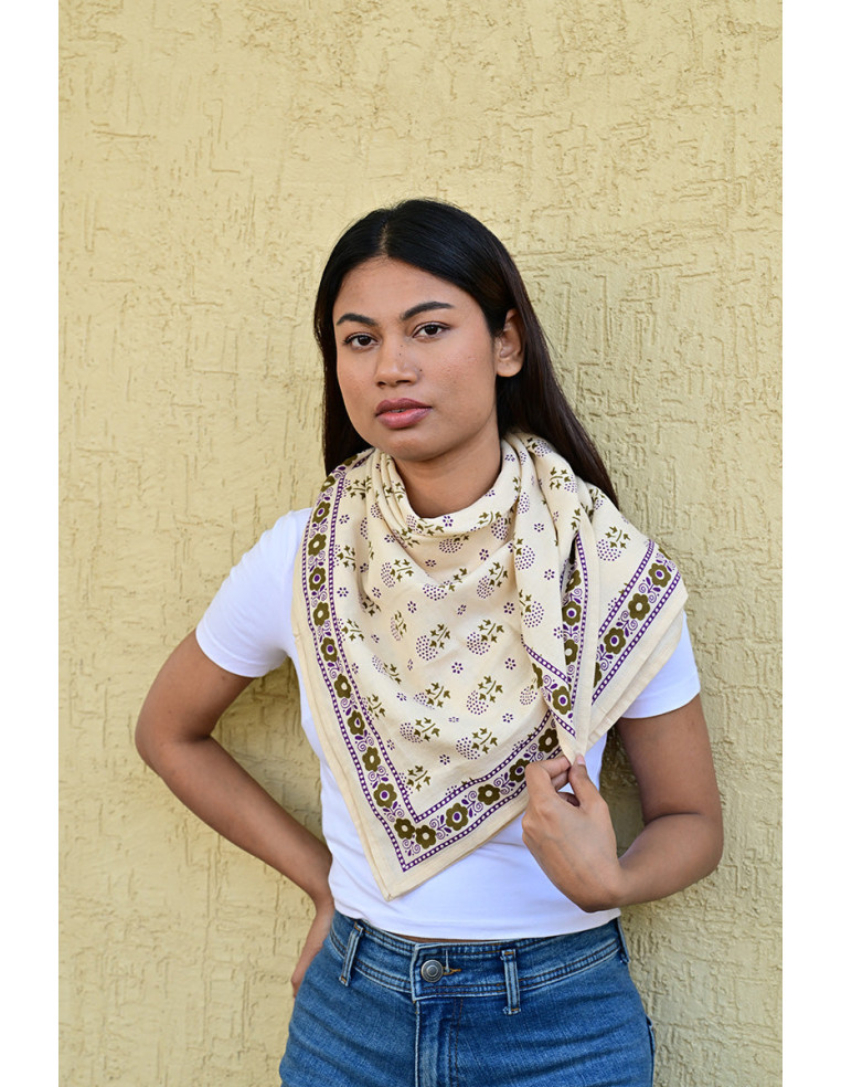 Femme portant le grand foulard Anastase Latte 100x100 cm noué autour du cou.