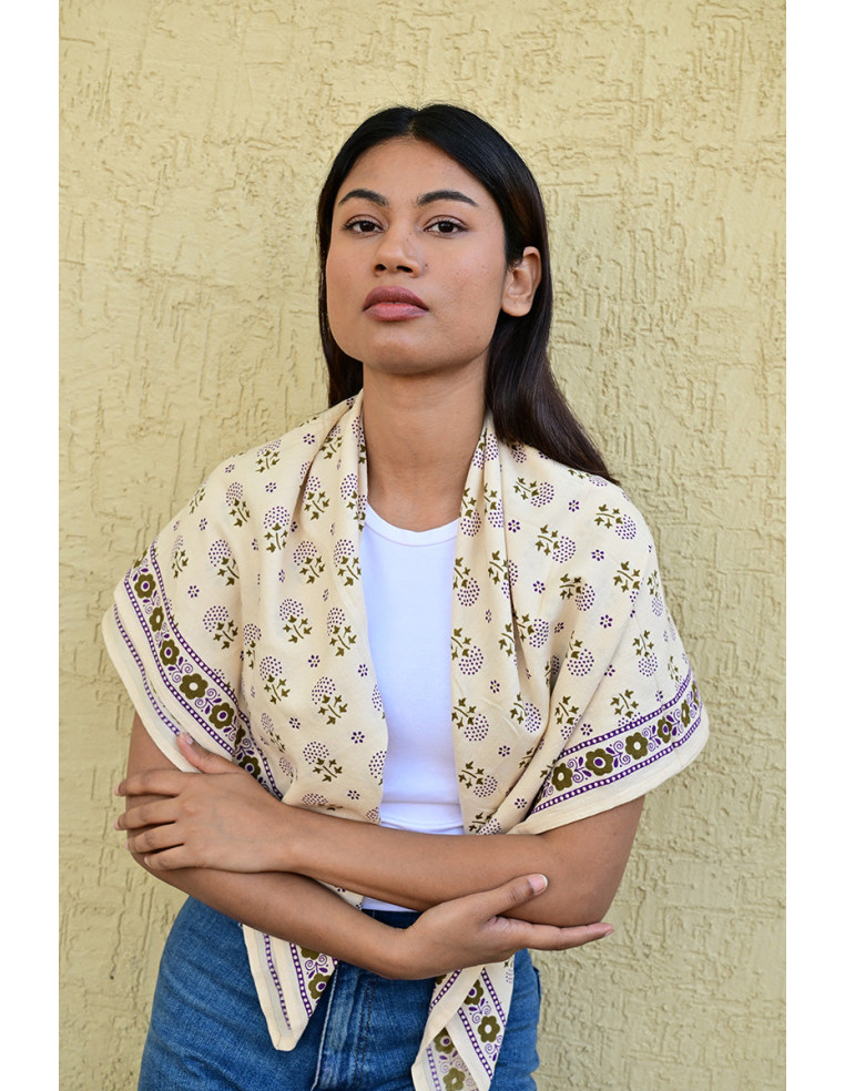 Femme portant le grand foulard Anastase Latte 100x100 cm sur les épaules.