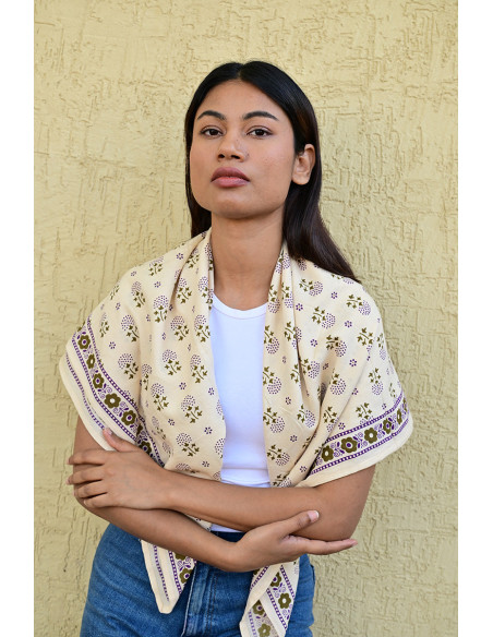 Femme portant le grand foulard Anastase Latte 100x100 cm sur les épaules.