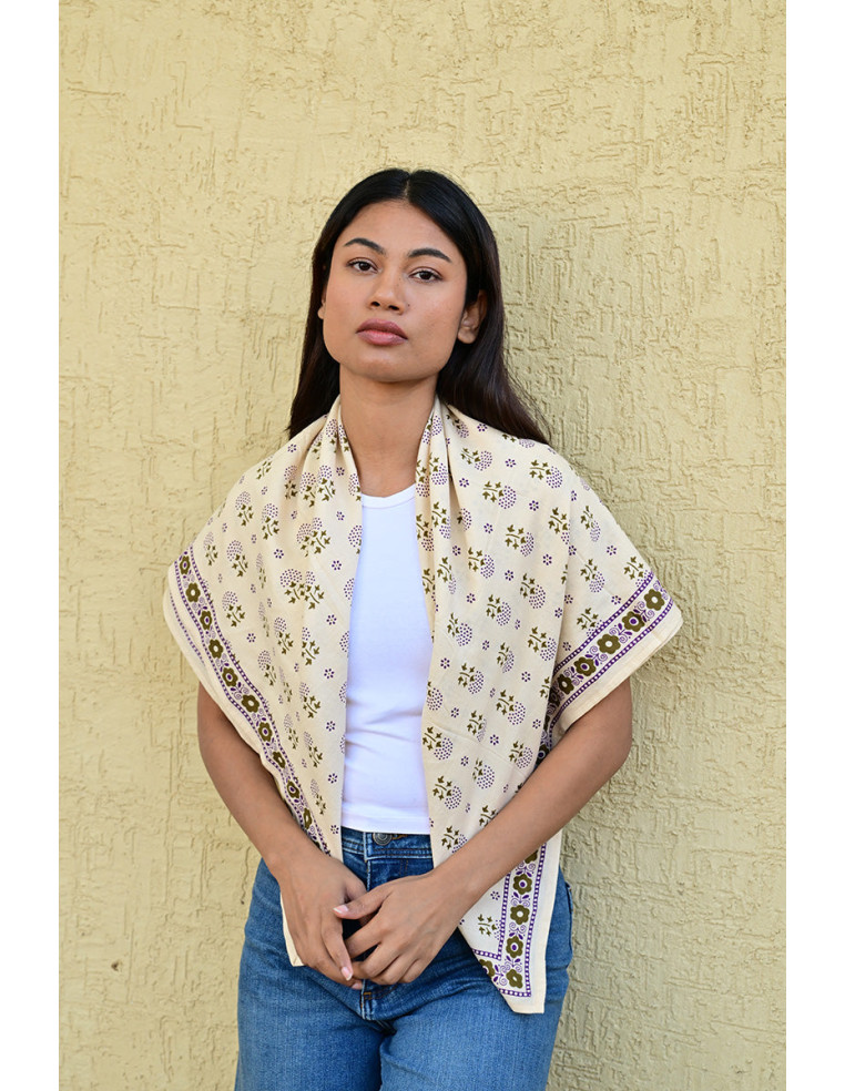 Femme portant le grand foulard Anastase Latte 100x100 cm sur les épaules.