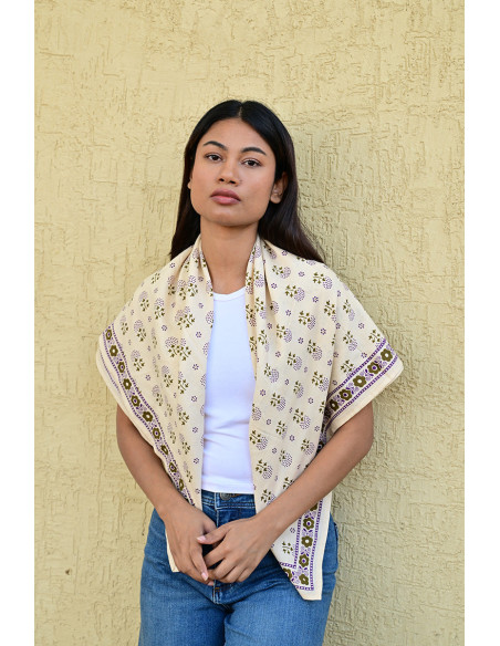 Femme portant le grand foulard Anastase Latte 100x100 cm sur les épaules.