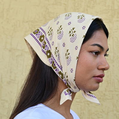 Femme portant le petit foulard Anastase latte 50x50 cm en bandana.