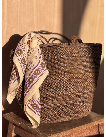 Petit foulard Anastase latte 50x50 cm porté comme accessoire de sac.