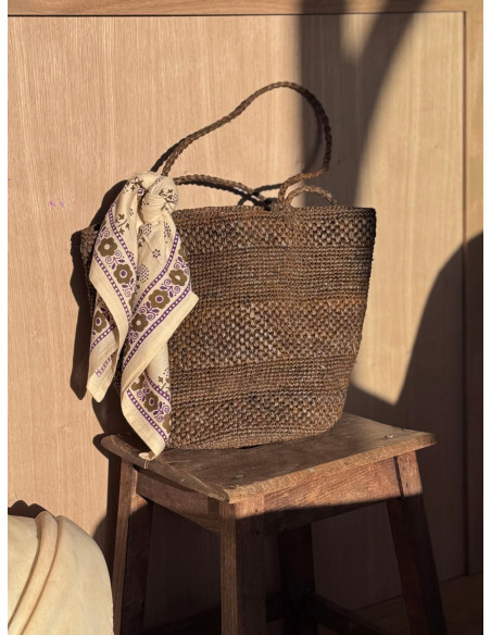 Petit foulard Anastase latte 50x50 cm porté comme accessoire de sac.