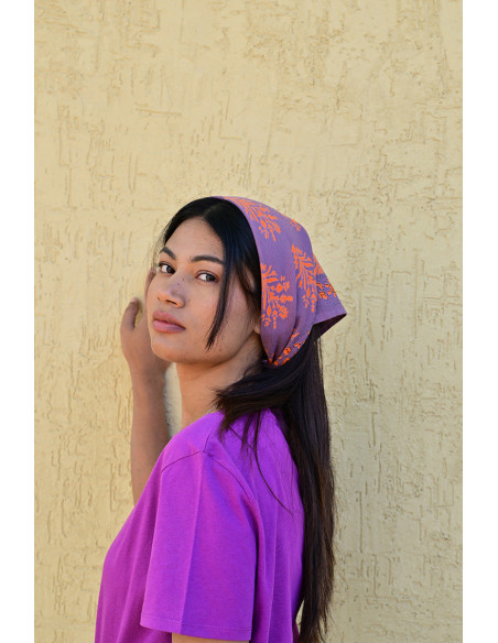 Bandana Galatie motifs floraux oranges porté en bandana.