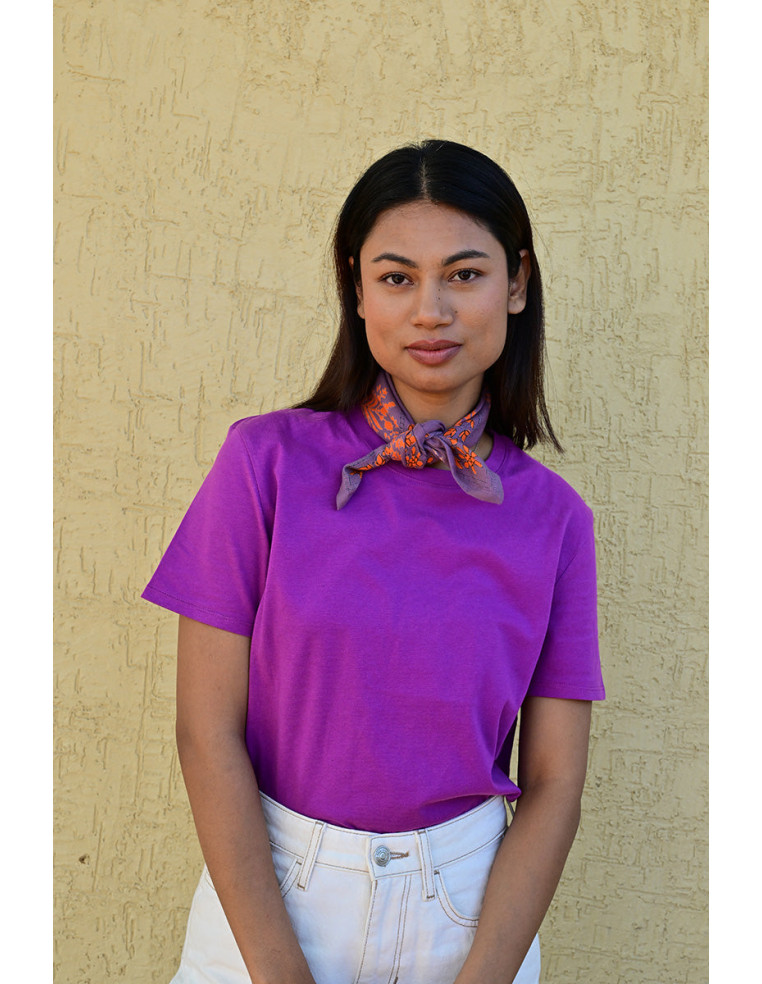 Bandana Galatie motifs floraux oranges porté noué autour du cou.